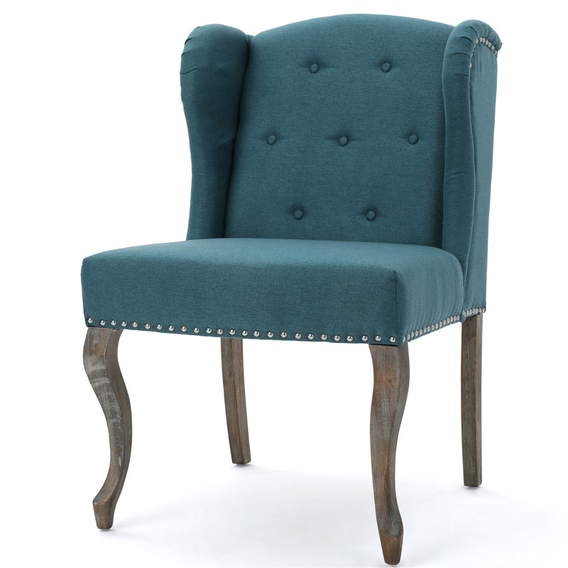 Fauteuil à oreilles bleu sarcelle avec boutons et pieds cloutés