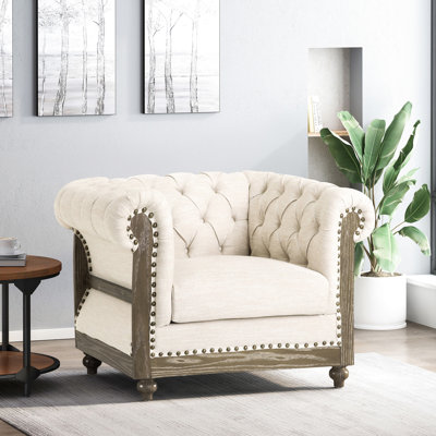 Magnifique fauteuil club avec capitonnage à boutons profonds, tissu beige, accoudoirs à volutes, garniture cloutée, pieds en bois de bouleau, cadre brun foncé, accoudoirs contemporains de P 33 po x P 39 po 28 po