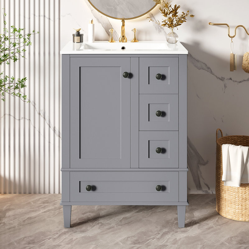 Meuble-lavabo gris de 61 cm (24 pouces) avec lavabo en céramique intégré, comprenant une tablette double sur la porte, des tiroirs à fermeture amortie et une porte d'armoire à fermeture amortie.