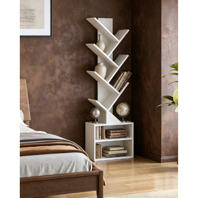 A Minimalist, Pure White Six-Tier Tree-Shaped Bookshelf. Its Slim Profile Saves Space, And—Featuring A Built-In Storage Cabinet—It Serves Equally Well For Both Organization And Decoration In A Variety Of Settings.