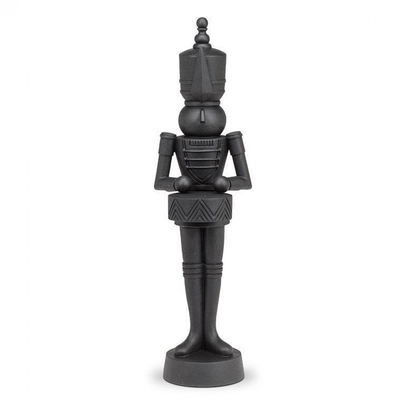 Soldat debout en noir avec une statuette de tambour