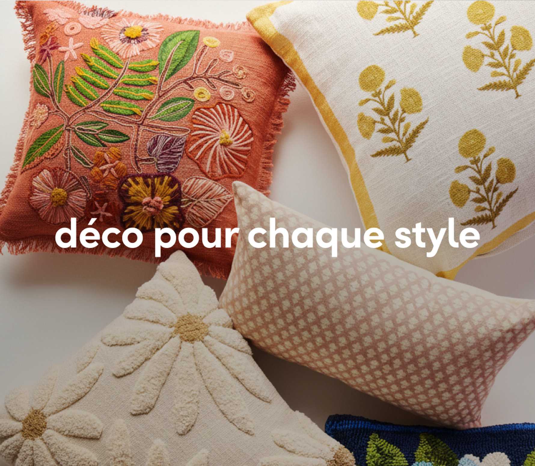 Coussins décoratifs colorés aux motifs et textures variés sur un canapé.