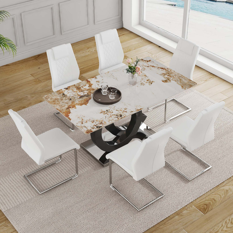 Ensemble de table et de chaises. Table en pierre frittée à motif marbré de 63 po x 31,5 po avec support en MDF en forme d'oc.