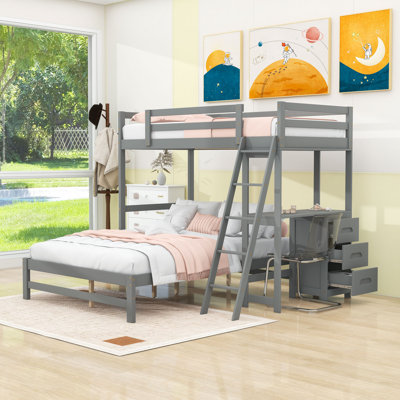 Lit simple superposé au dessus d'un lit double avec bureau et tiroirs, échelle
