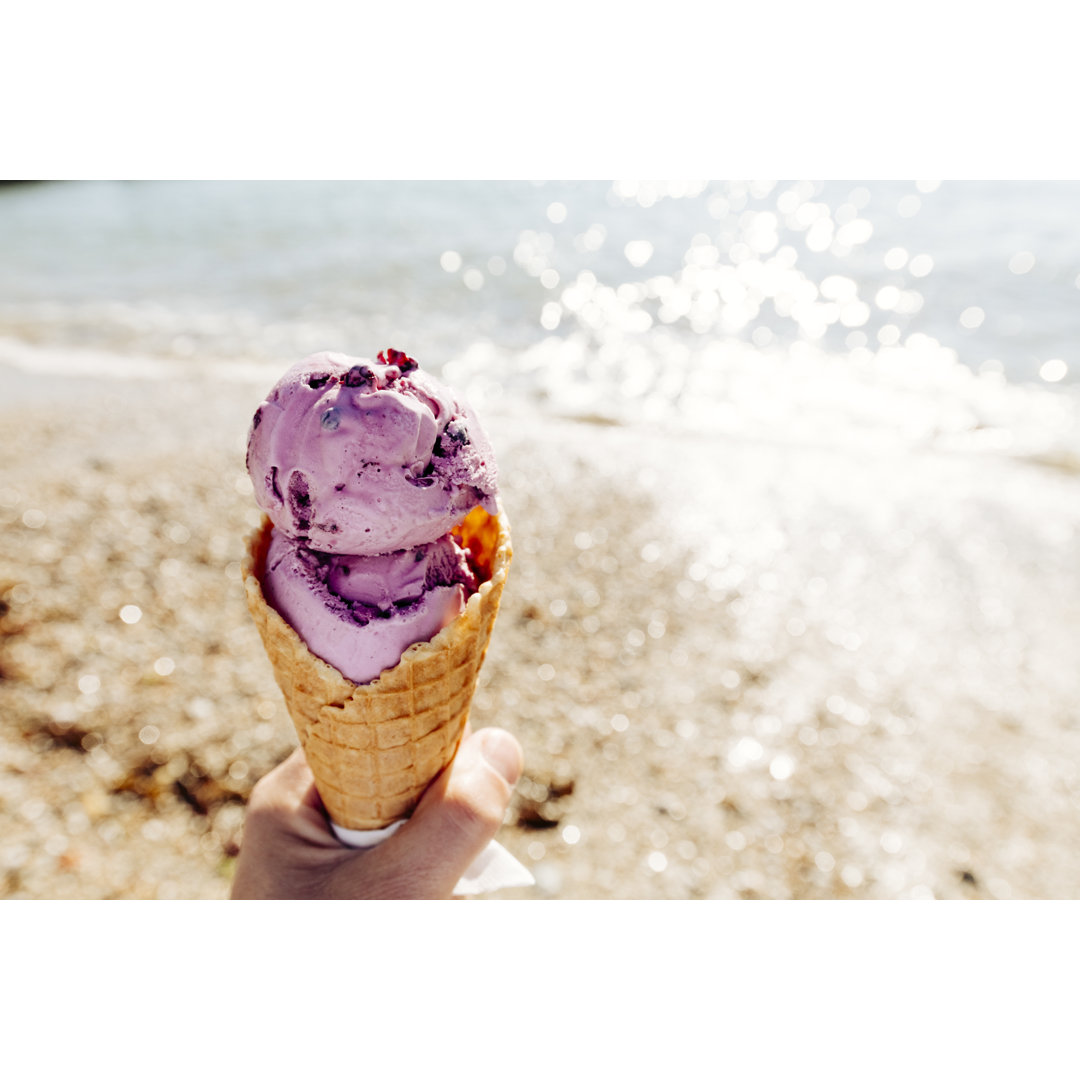 POV Of Hand Holding A Purple Blueberry Flavoured Ice Cream von Creacart - Kunstdrucke auf Leinwand ohne Rahmen