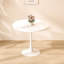 Table ronde blanche avec piètement en acier massif pour un usage quotidien dans un salon moderne et stable
