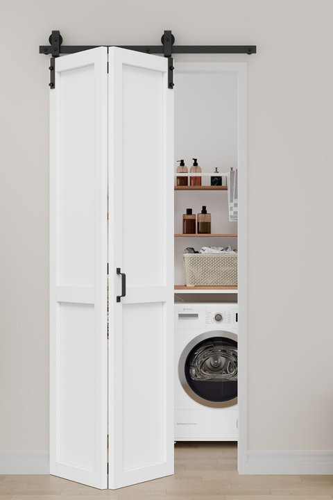 White bifold barn door installed in a laundry room opening with black hardware and an accessible shelf and washer unit inside.