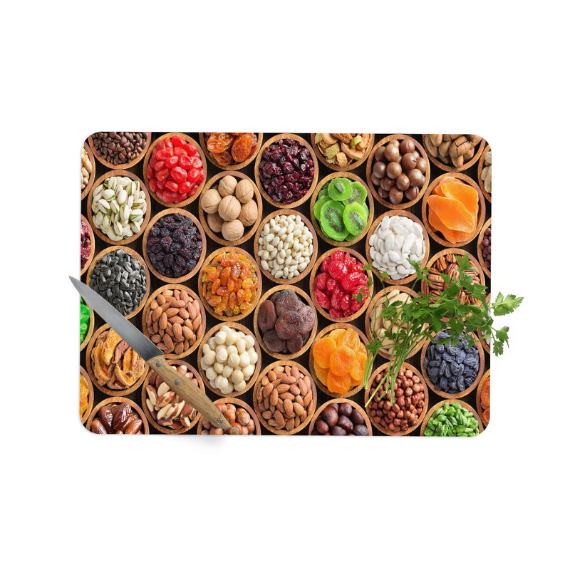 Élégante planche à découper en verre avec une représentation colorée moderne d'une planche à découper avec des fruits et des noix frais
