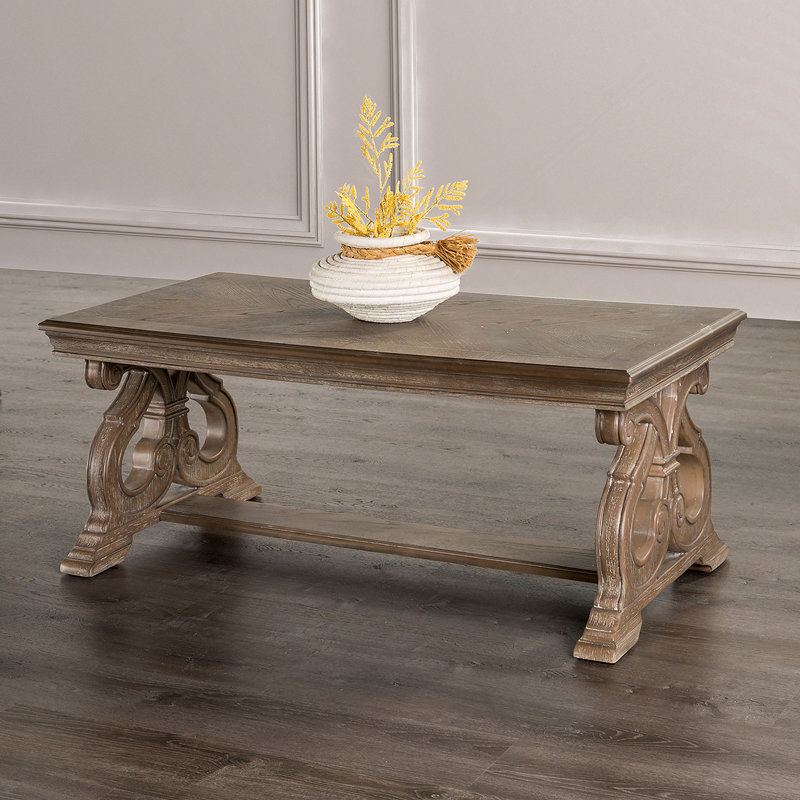 Table basse de style traditionnel avec pieds à volutes courbés et finition chêne vieilli, parfaite pour les salons élégants