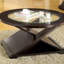 Table basse d'appoint de style contemporain avec base unique en forme de croix et plateau en verre de 5 mm soutenu par une structure en bois massif au fini espresso