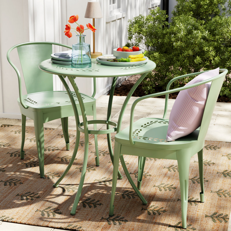 Ensemble bistro traditionnel pour 2 personnes avec table ronde, fauteuils en fer forgé, motif floral et design empilable Alan
