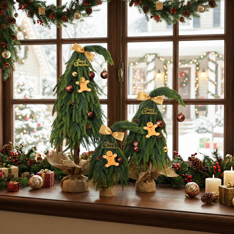 Sapins de Noël fantaisie en 3 parties, à cime incurvée, ornés de décorations dorées, de motifs en pain d'épice et de bases en toile de jute