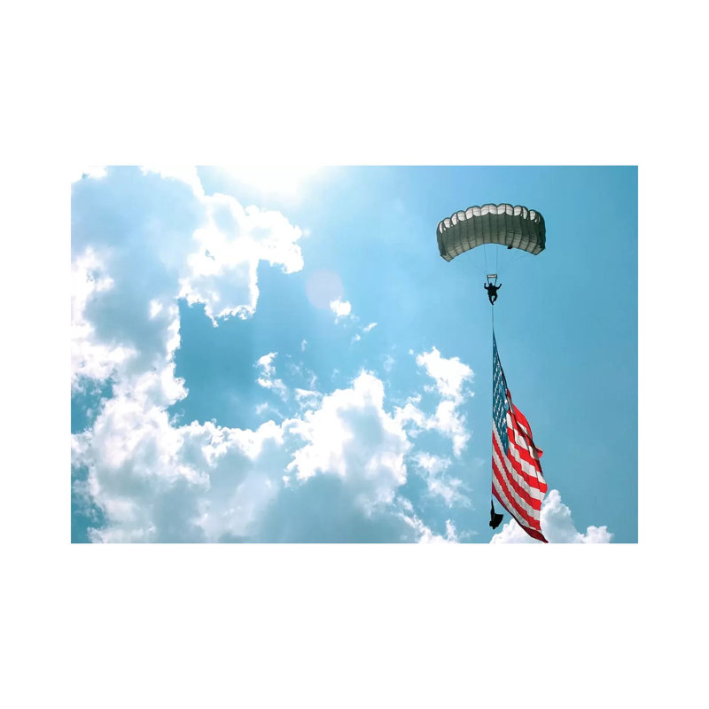 A Skydiver Carries A US Flag While Descending Through The Sky by Stocktrek Images - Wrapped Canvas Print