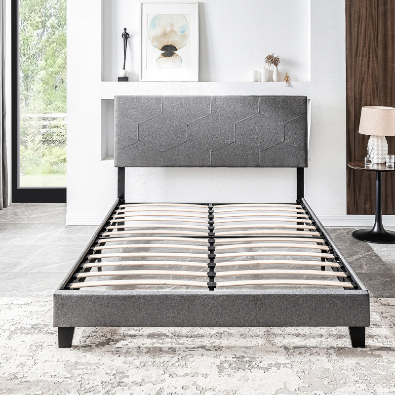 Lit tapissier grand, gris, avec support de lit en lattes de bois gris, offrant un confort optimal