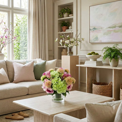 Hortensias, pivoines et tulipes disposés dans un vase en verre