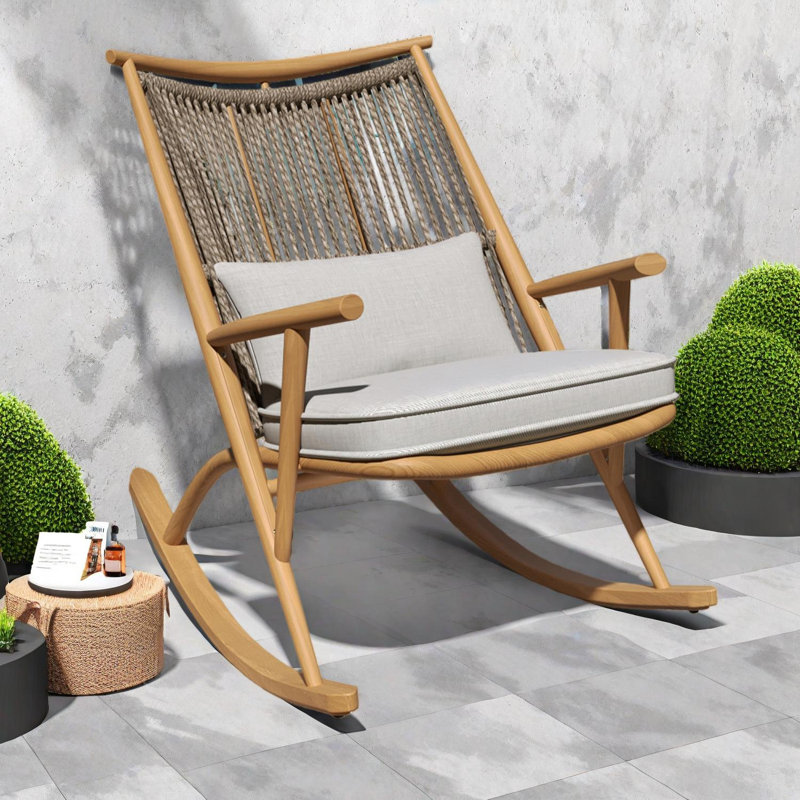 Chaise berçante d'extérieur avec structure en fer robuste, dossier et coussins en rotin