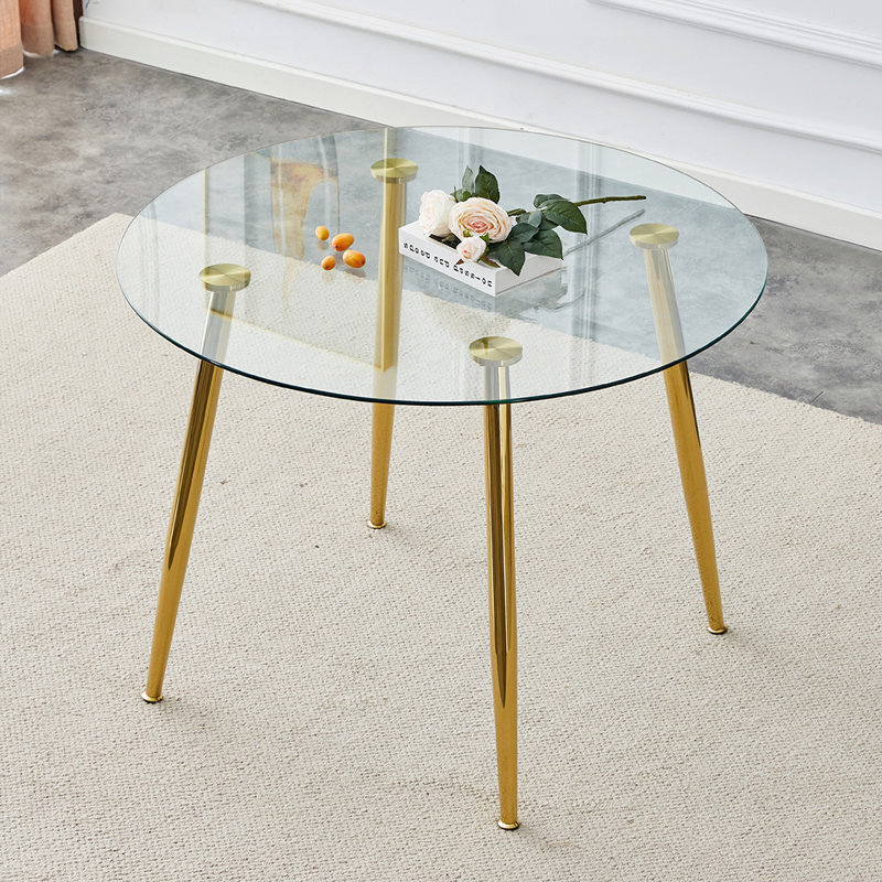 Table de salle à manger élégante avec plateau en verre et pieds plaqués or pour les petits espaces et les réunions de famille.