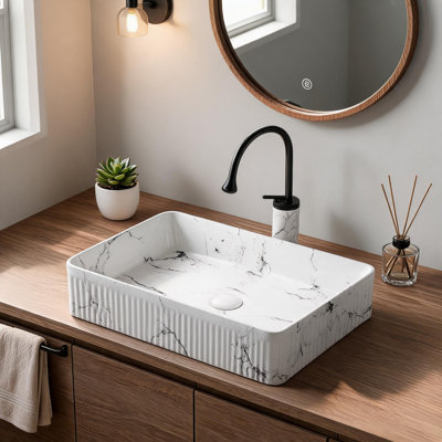 Vasque ovale en céramique effet marbre noir et blanc (51 x 36 cm) avec robinet et bonde.