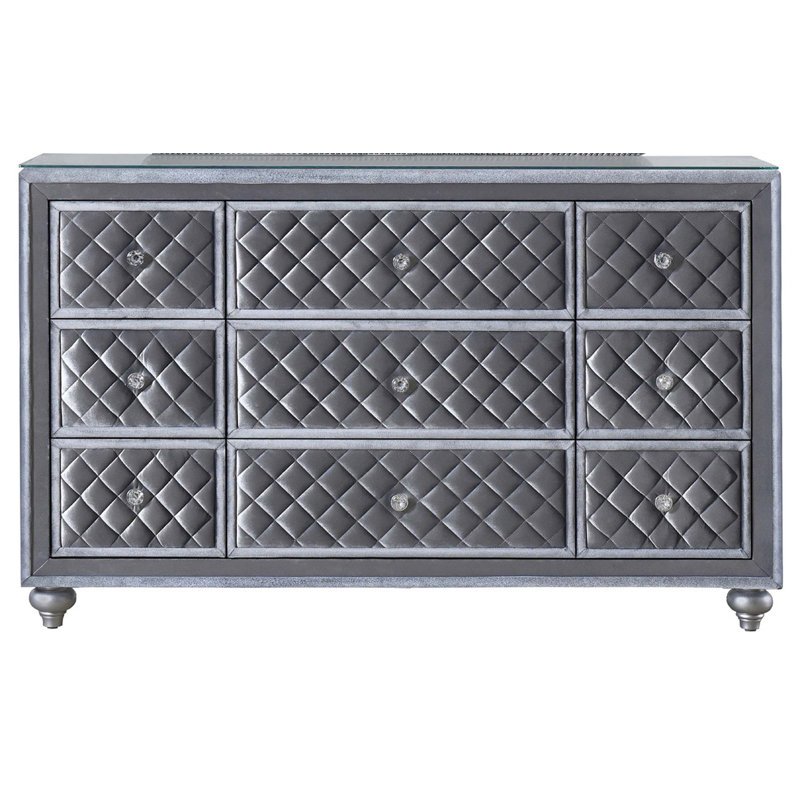 Commode élégante à 9 tiroirs avec plateau en verre trempé, façades capitonnées en velours et poignées en faux cristal pour les chambres glamour
