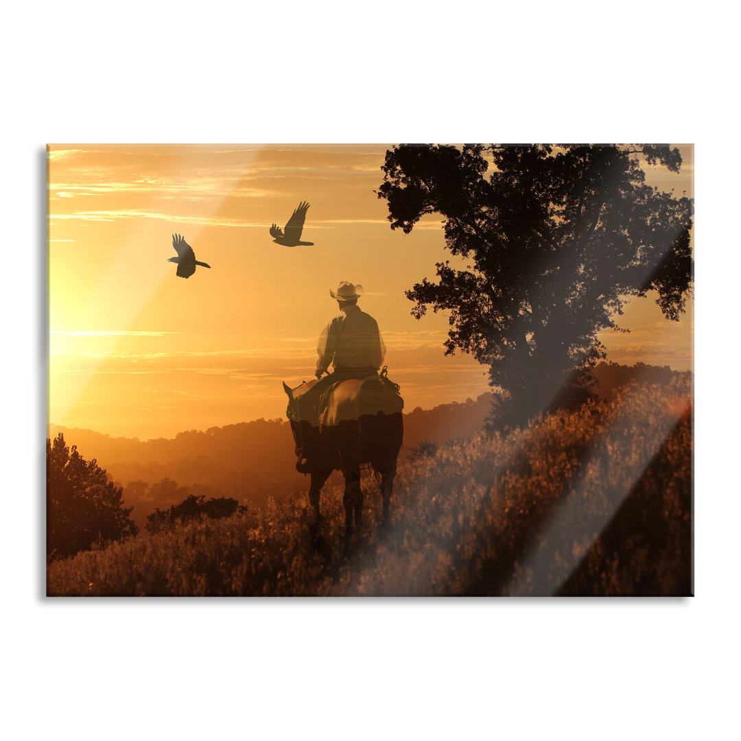 Glasbild Ein Cowboy bei Sonnenuntergang