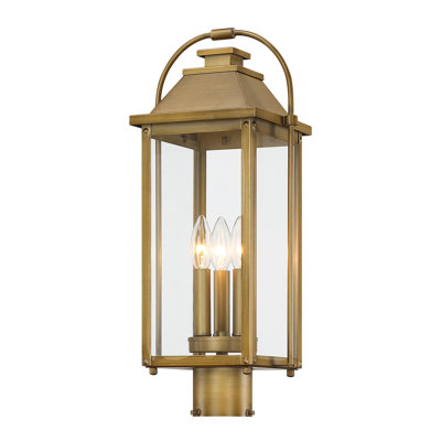 Lanterne extérieure à trois lumières en laiton antique peint, fixée sur un pilier.