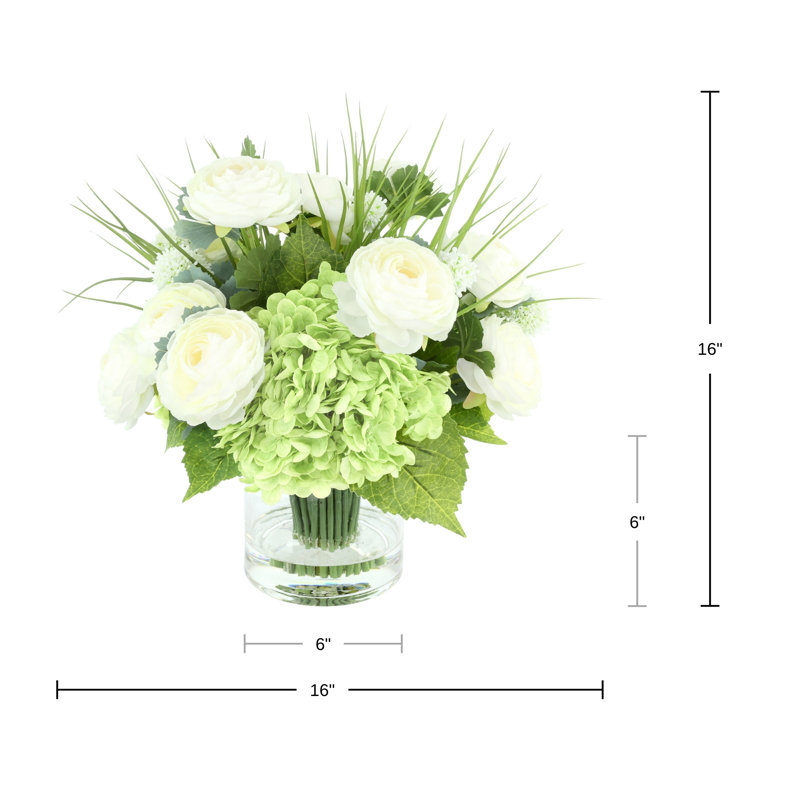 Renoncule, hortensia et herbe disposés dans un vase en verre