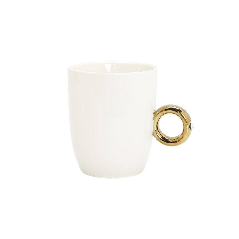 Tasse blanche avec poignée en anneau doré et détails en cristal transparent