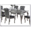 Table de salle à manger élégante à plateau en verre avec base argentée et six chaises à dossier capitonné pour les salles à manger modernes et classiques