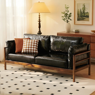 A black leather double sofa with cushions