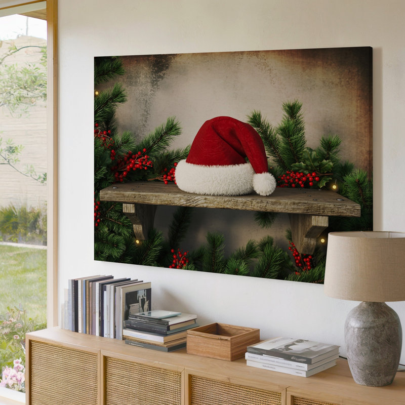 Toile une scène rustique douillette avec un art mural classique rouge et blanc, un chapeau de père Noël reposant sur une étagère en bois ornée d'une toile luxuriante moderne