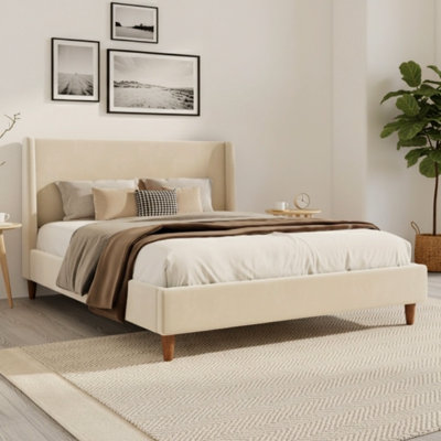 Lit plateforme tapissier moderne en velours beige avec tête de lit à oreilles et pieds en bois de noyer