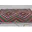 Tapis turc vibrant fabriqué à la main dans des motifs géométriques rouge, vert et orange pour un décor traditionnel