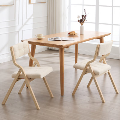 Chaise pliante au design élégant avec structure en bois massif et dossier et siège rembourrés capitonnés