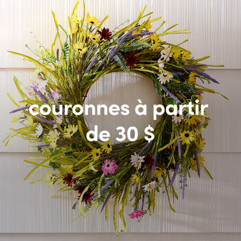 Une couronne d'été extérieure colorée avec des fleurs sauvages jaunes, roses et violettes accrochée sur un revêtement blanc à partir de 30 $.