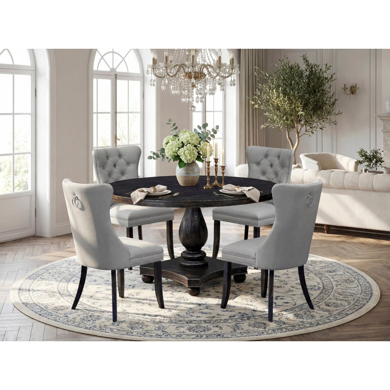 L'ensemble de table de salle à manger 5 pièces se compose d'une table ronde de 54 po avec piédestal et 4 chaises Parson en polyester gris clair, noir sablé
