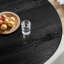 Élégante table de salle à manger ronde noire avec base conique élégante, design contemporain de luxe pour des espaces de vie sophistiqués