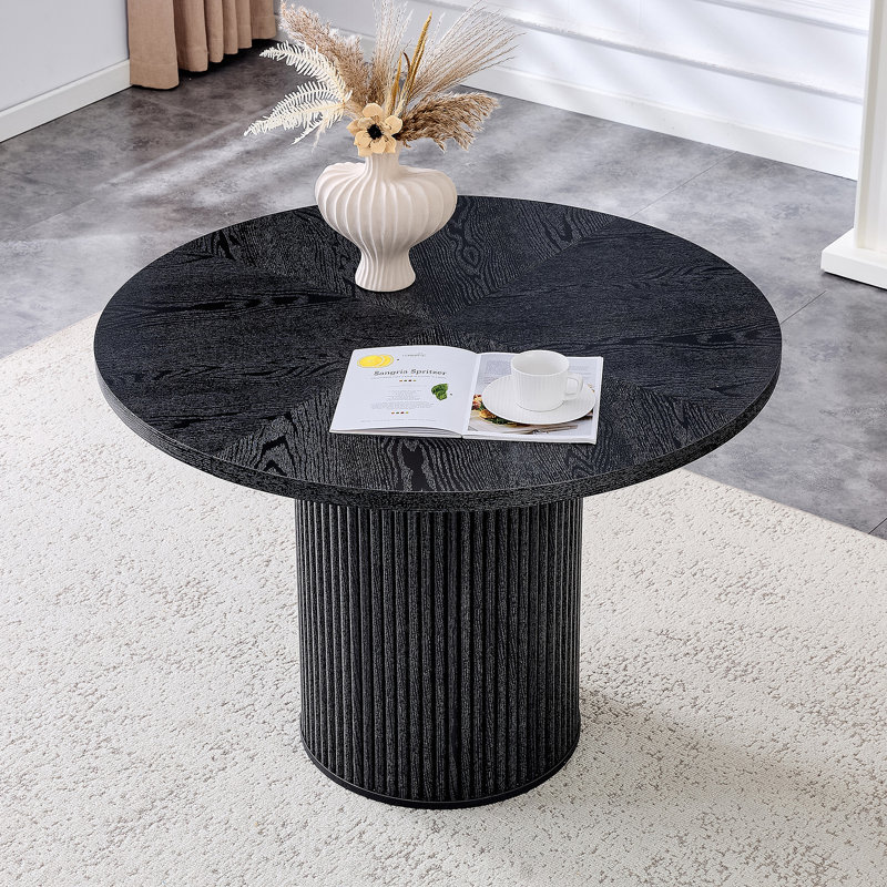 Une table de salle à manger circulaire épissée moderne d'un diamètre de 42 pouces, présentant des textures de couleur de bois noir en forme d'éventail en diagonale, interprétant l'esthétique et la fonctionnalité de la maison.