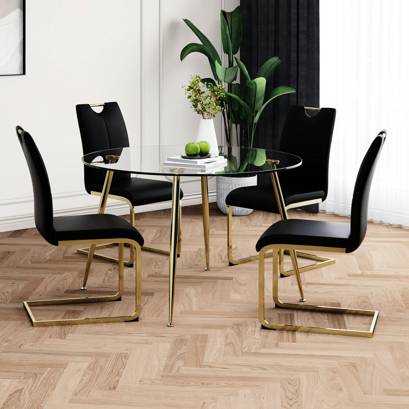 Chaise de salle à manger noire avec table ronde en verre et pieds dorés