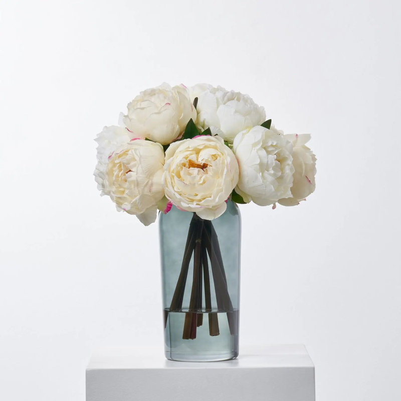 Pleine illusion de pivoines blanches et crème dans un vase en verre fumé