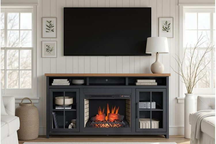 wall-mounted flat-screen TV above a black electric fireplace media console in a bright farmhouse-style living room with white paneled walls and neutral decor