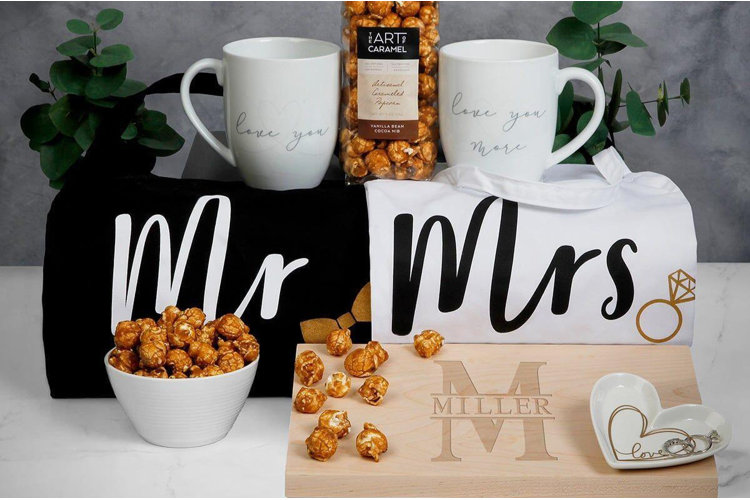 mr. and mrs. couple's gift basket featuring kitchen towels, mugs, personalized cutting board, and popcorn