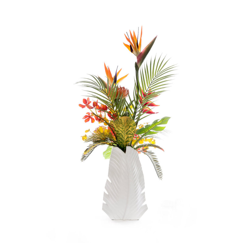 Arrangement de fleurs tropicales dans un vase à feuilles blanches