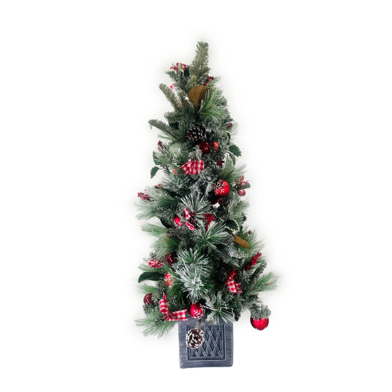 Arbre de Noël de table enneigé à feuilles persistantes avec ornements, baies et arcs non éclairés