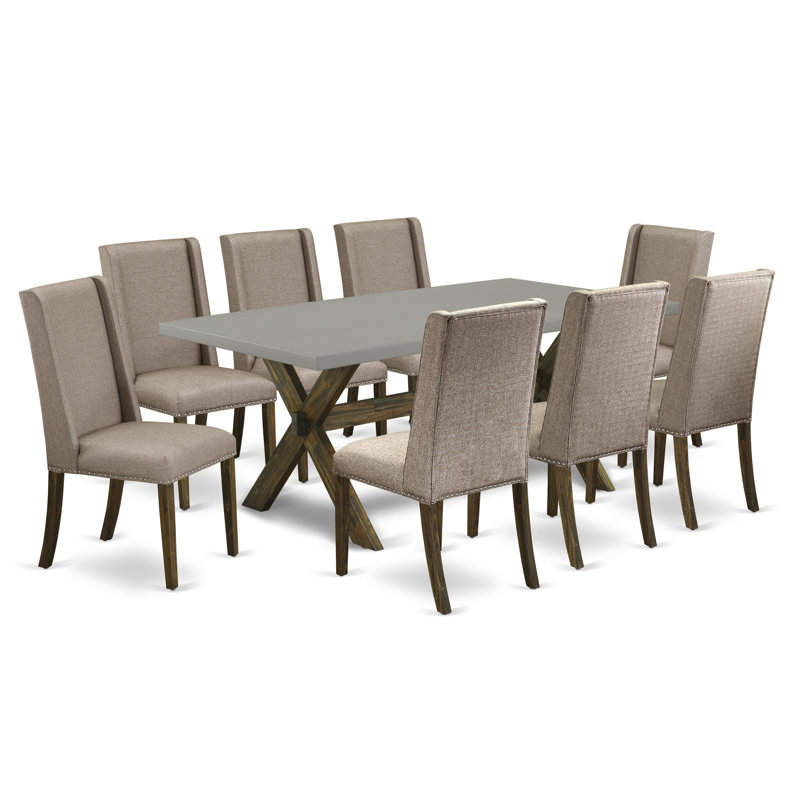 Cet ensemble de salle à manger 9 pièces comprend une table de salle à manger rectangulaire avec des pieds en X et 8 chaises Parson rembourrées en tissu kaki foncé, finition jacobine patinée