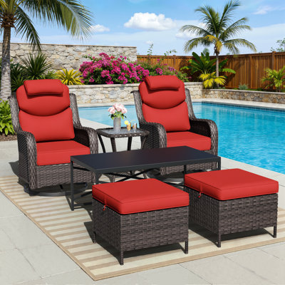 Ensemble de mobilier d'extérieur en rotin pour 2 personnes Adcox avec chaises pivotantes, coussins de repose-tête, repose-pieds, tables et coussins rouges