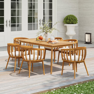 Keeton Modern Coastal 7-Piece Outdoor Dining Set With Acacia Wood Table And Slatted Back Chairs With Cushions by Corrigan Studio