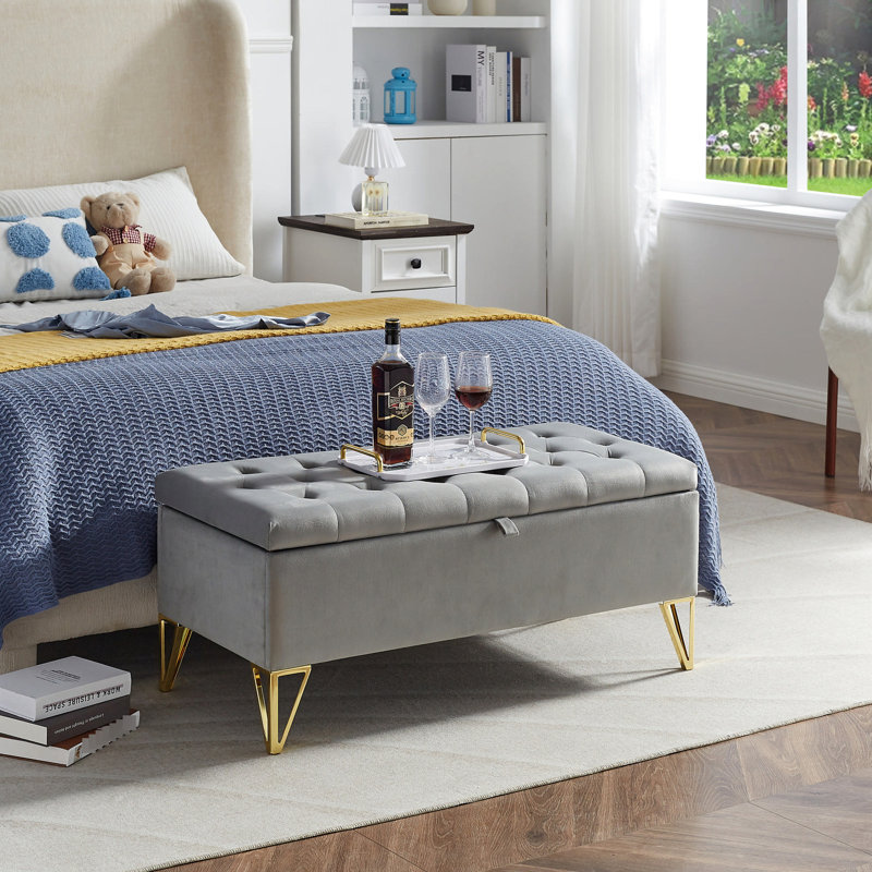 Élégant banc de rangement rembourré en velours gris avec support stable et pieds dorés pour la chambre à coucher