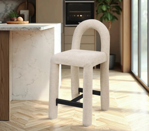 Beige upholstered bar stool with an arched backrest and black metal footrest in a modern kitchen.