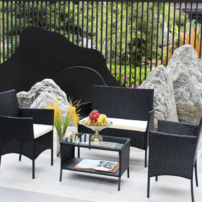 Ensemble de patio 4 pièces - Mobilier d'extérieur avec coussins beige chaud, comprenant des fauteuils, une table basse en verre trempé.