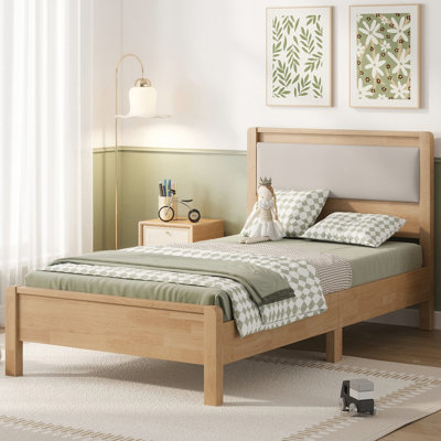 Lit simple XL en bois d'hévéa massif avec tête de lit rembourrée, renforcé par des pieds de soutien centraux, de couleur naturelle.